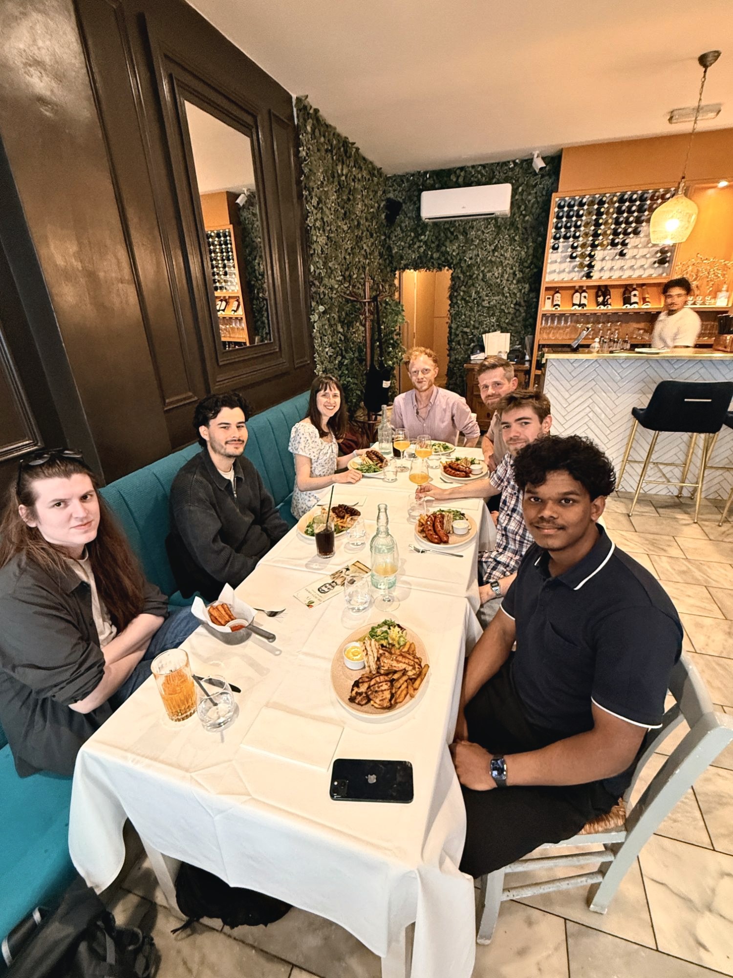 The team smiling round a table at a team lunch in a restaurant