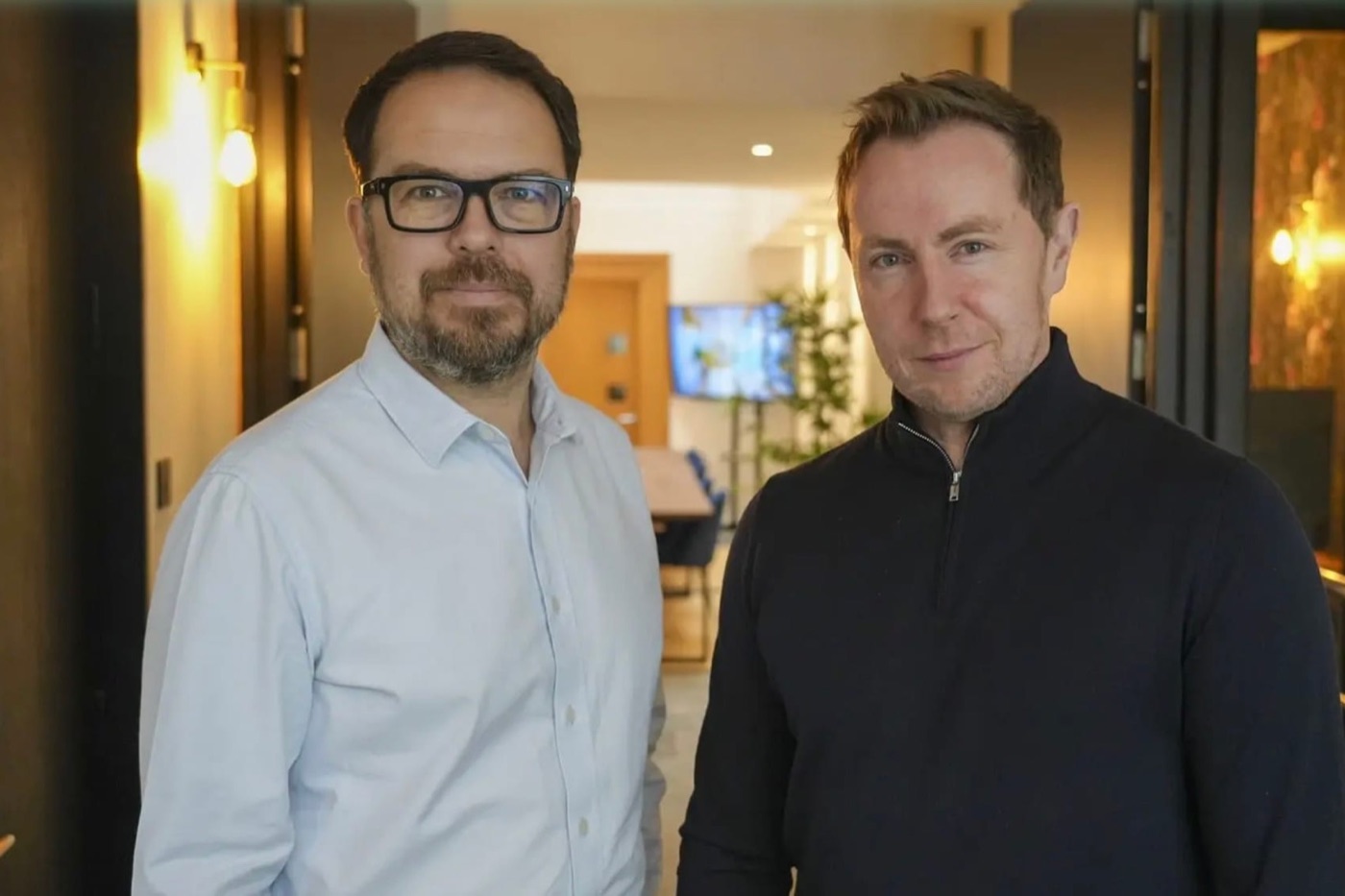Albie.ai’s two founders standing side by side in an office corridor.