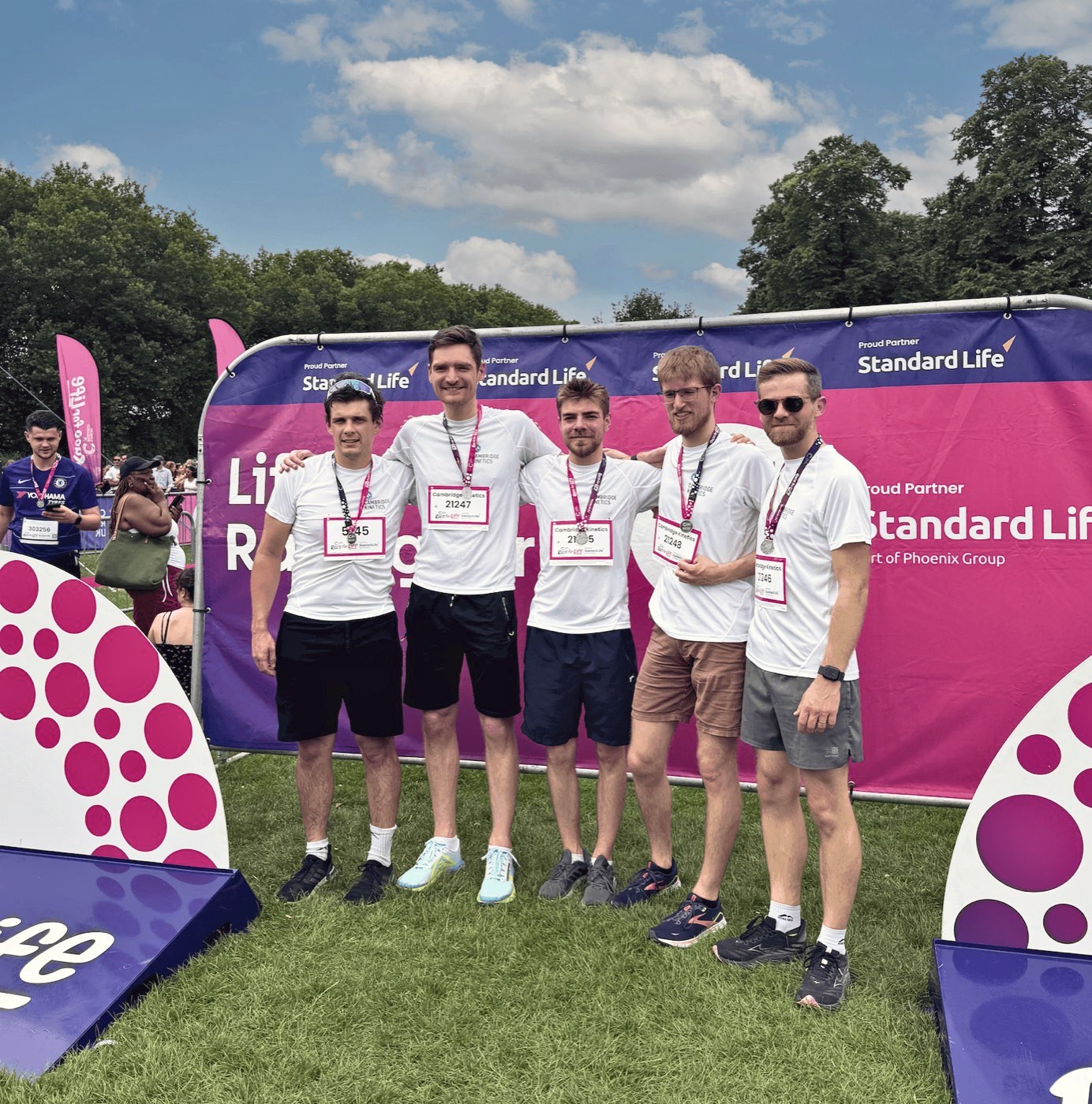 Five members of the team in white T-shirts with their medals at Race for Life