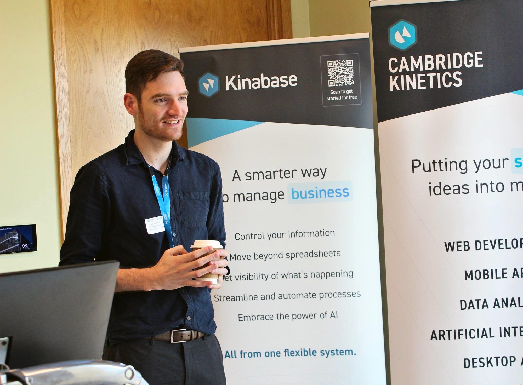 Jason Mashinchi smiling, coffee in hand, in conversation at our Kinabase and Cambridge Kinetics stands